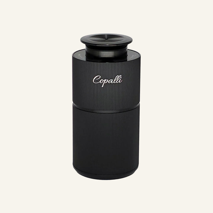Our Black Copalli mini diffuser with "copalli" branding; waterless scent diffuser with fine vertical ridges.
