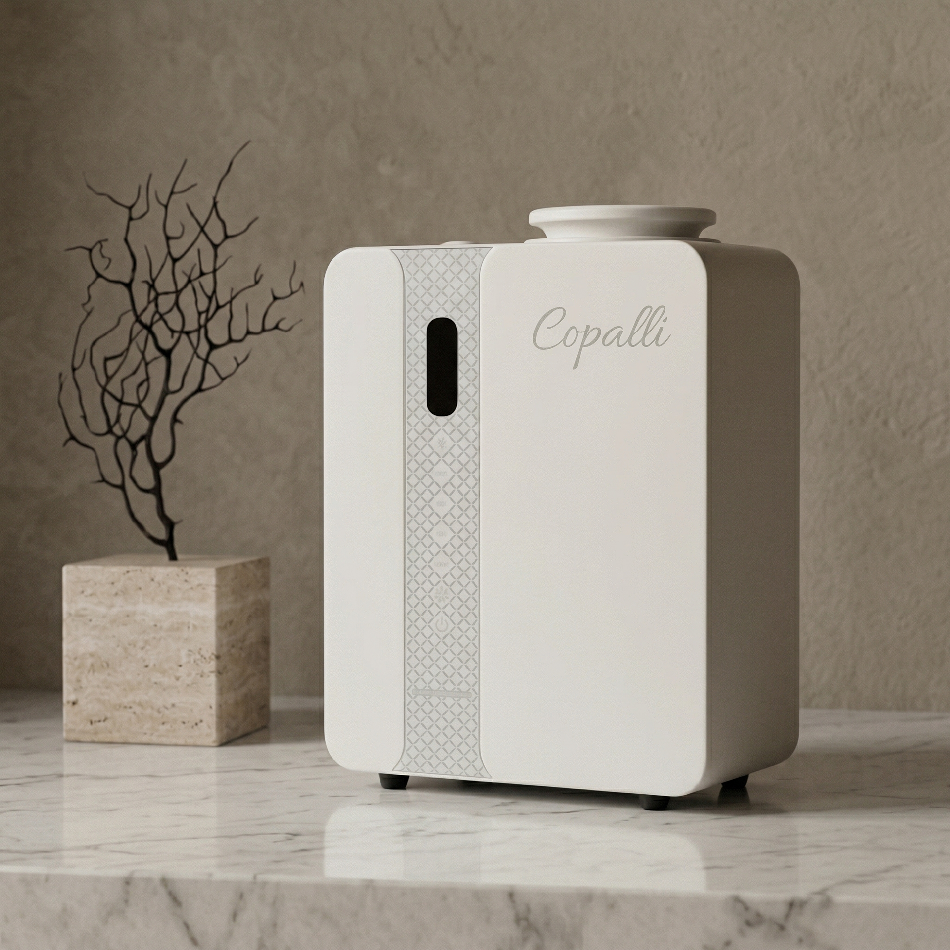 Our white Copalli Pro Diffuser placed on a marble surface next to a decorative dried branch, showcasing its sleek industrial design and minimalist branding against a warm, neutral wall.