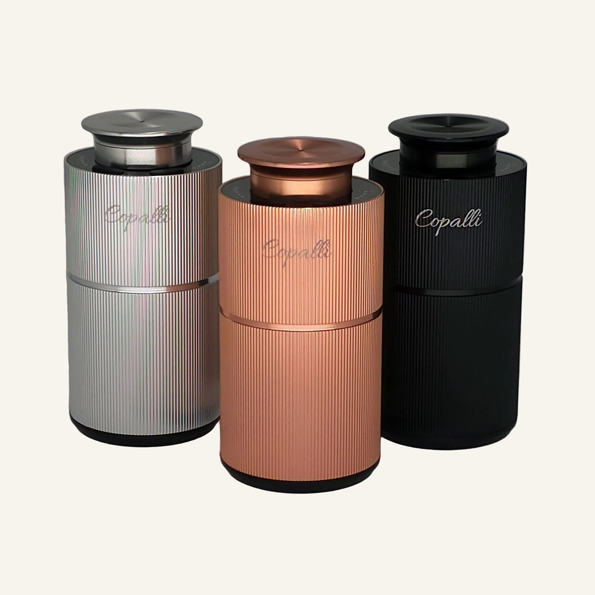 Copalli Mini diffusers in silver, rose gold, and black with 'Copalli' branding on a gray background.