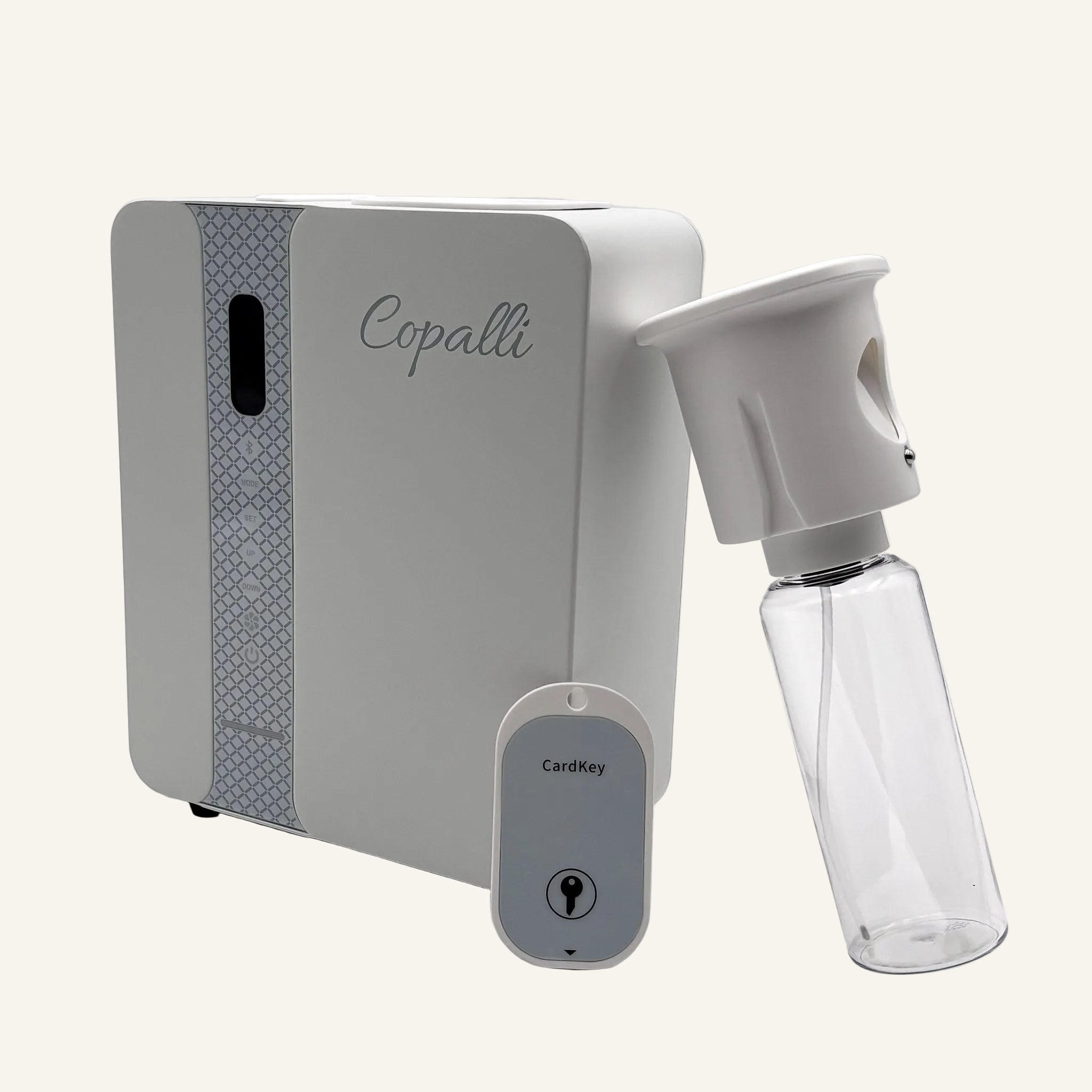 Our white Copalli Pro Diffuser shown from a side profile with its internal fragrance bottle and a key, highlighting its professional-grade waterless design for commercial scenting.