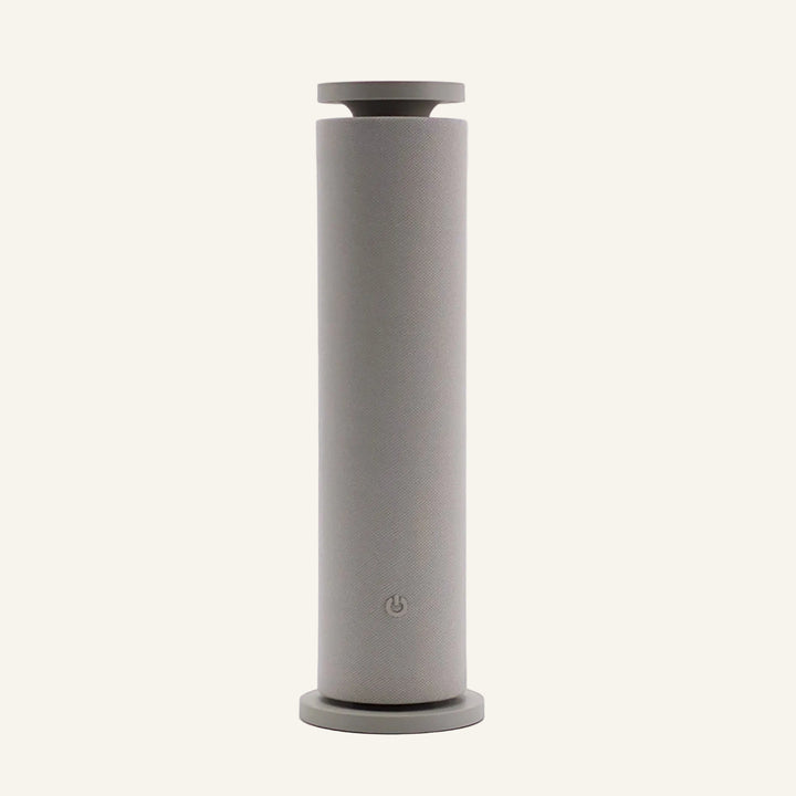 Our Beige Copalli Tower Diffuser featuring a tall, slender cylindrical design with a minimalist matte finish and a discreet power icon, centered on a light cream background."