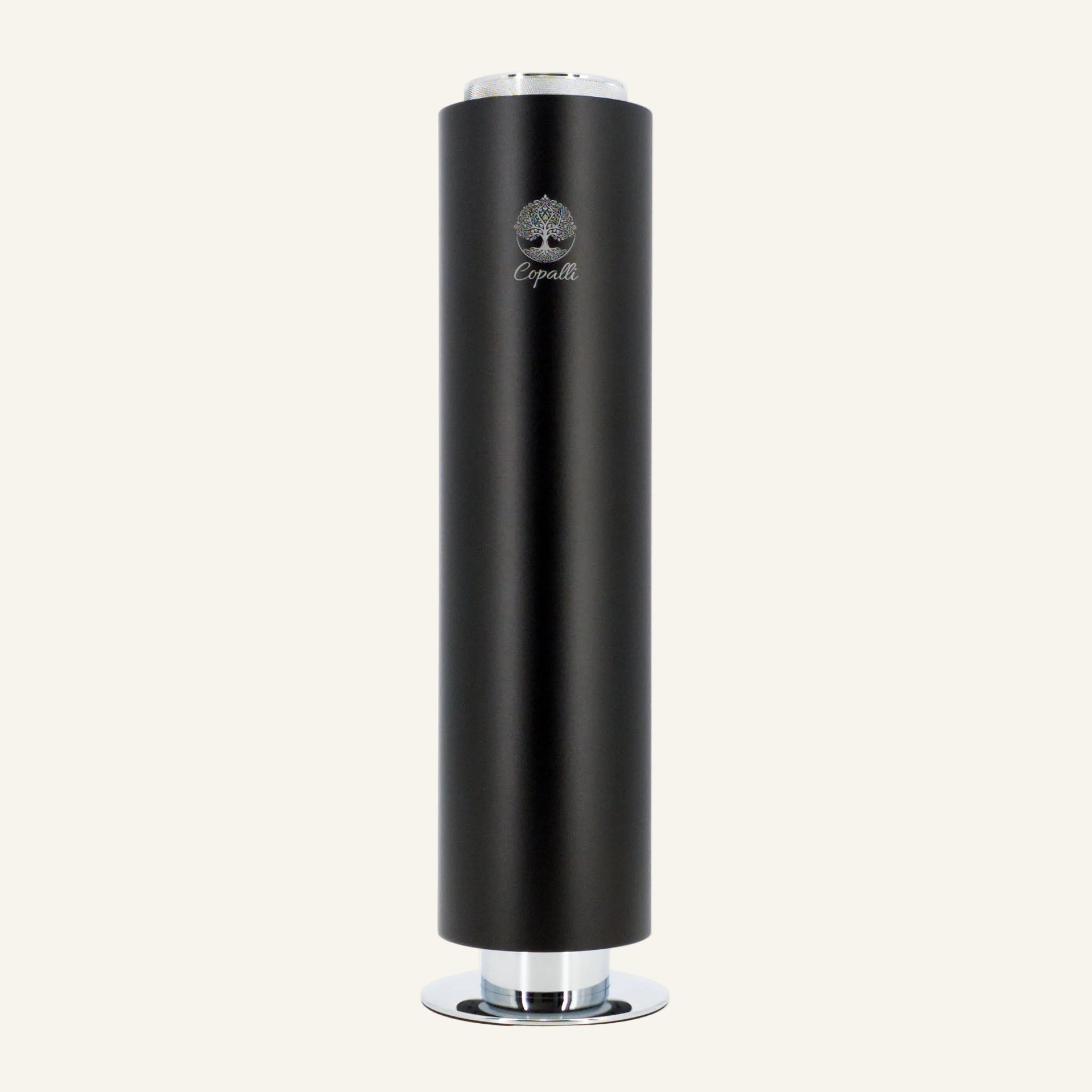 Our black Tower Pro Diffuser by Copalli, a freestanding cylindrical waterless scent machine with a minimalist tree logo on a light cream background.