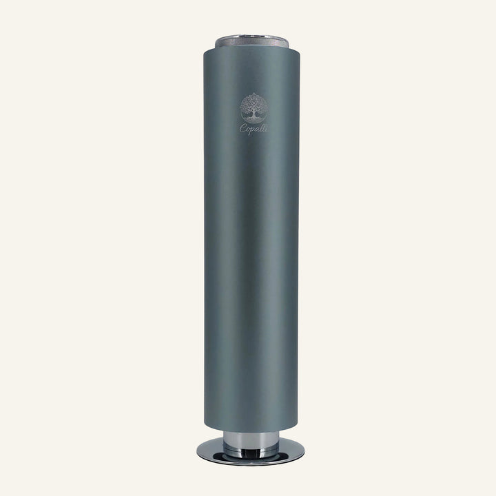 Our Nebula Blue Tower Pro Diffuser by Copalli, featuring a deep metallic blue finish and a minimalist tree logo, centered on a light cream background.