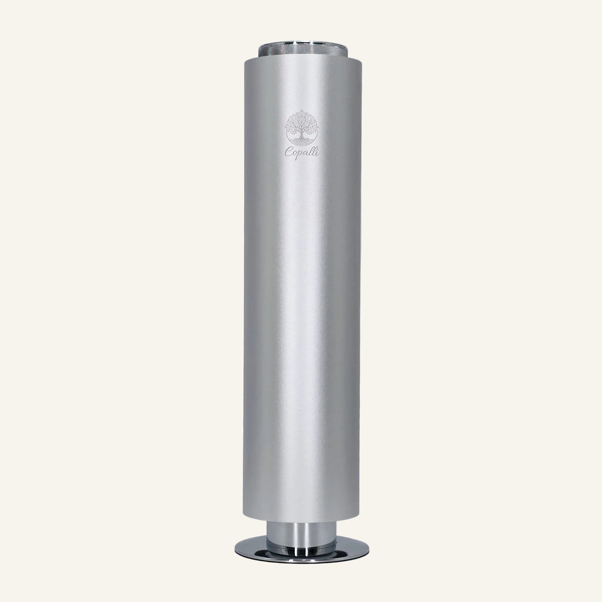 Our silver Tower Pro Diffuser by Copalli, featuring a sleek cylindrical aluminum body and minimalist tree logo, centered on a light cream background.